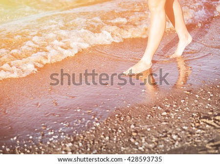 Woman walking on sandy beach in hot summer sun, enjoying vacation