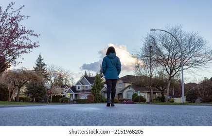 Woman Walking On A Street In A Residential Neighborhood Of Modern City Suburbs. Fraser Heights, Surrey, Vancouver, BC, Canada.