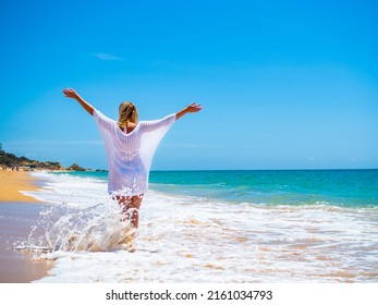 Woman walking on sunny beach - Powered by Shutterstock