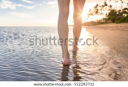 Woman walking on a tropical beach at sunset. 
