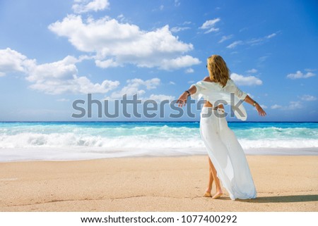 Woman walking on the wild beach of the island of Lefkada in Greece 