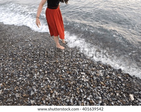 woman walking over the shore in summertime 