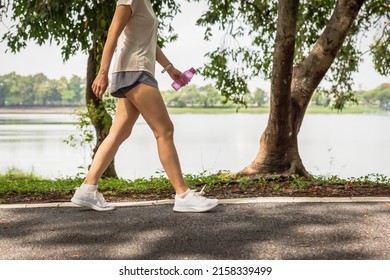 Woman walking in the park with bottle water in her hand health care concept - Powered by Shutterstock