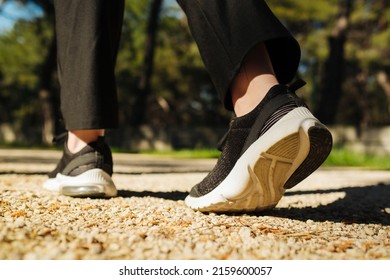 Woman Walking In The Park, Outdoors. Taking A Step. New Life Concept. Sportswoman Exercising Outdoors. Back View, Selective Focus On Sneaker.