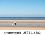 Woman walking with pomeranian spitz puppy on the beach at Cote d