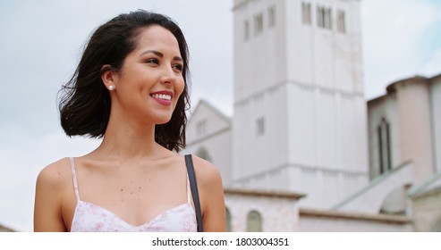 Woman Walking In Rural Town Square In Sunny Day.Woman Walking And Smiling In Assisi Square.Woman Walking With Bell Tower In Background. Handheld Close Up
