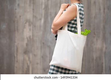 Woman Walking And Shopping Fruits And Vegetables With Reusable Cotton Eco Produce Bag. Zero Waste Lifestyle Concept