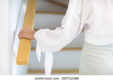 A Woman Walking Up The Stairs In The House