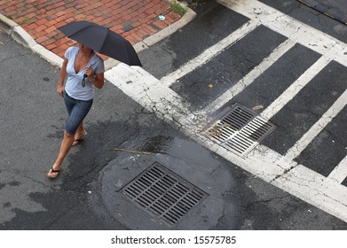 Woman Walking In Street With Umbrella.