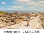 Woman walking through the Phoenician city of Tharros. Sardinia, Italy