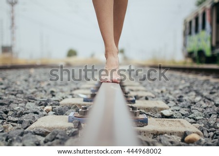 Woman walking in train railway, detail shot of the feets with ba