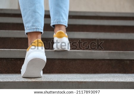 Woman walking upstairs outdoors, closeup