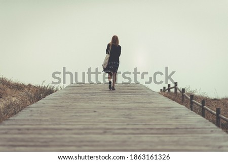 woman walks away and walks towards the horizon