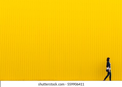 Woman Walks Near Yellow Wall, Copy Space Background