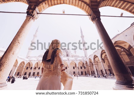 Woman wanting her man to follow her in vacation in front of blue mosque in turkey ,Istanbul .Follow me concept