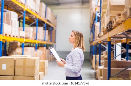 Woman Warehouse Worker Or Supervisor With Clipboard.