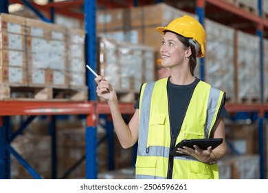 Woman warehouse worker working at warehouse. Warehouse worker working with digital tablet in warehouse - Powered by Shutterstock