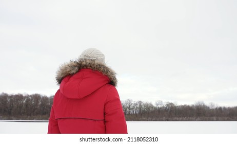 Woman In Warm Hooded Winter Coat Standing Outdoors In White Snowy Frosty Countryside Landscape Background. Christmas Season