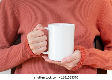Woman in warm sweater is holding white mug in hands - Shutterstock ID 1681383370