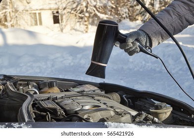  Woman Warming Up The Engine Of Her Car Using Hairdryer In Frosty Winter                             