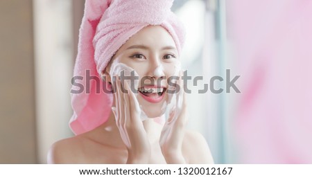 woman wash her face in the bathroom after shower