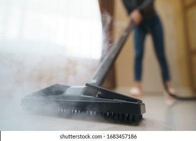 Woman Washes The Floor With A Steam Mop.