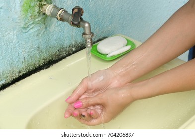 Woman Washes Her Hands In The Sink On The Street. Poor Sanitation.