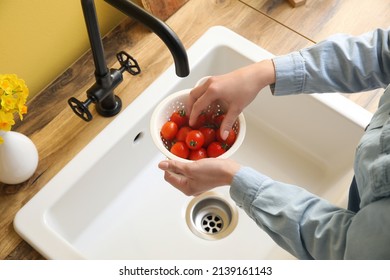 Woman Washing Cherry Tomatoes In Colander Over Sink, Closeup