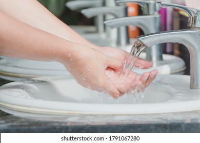 Woman washing and cleaning hands with soap on basin with water  to protect against coronavirus (COVID-19) and diseases in the public park, Health care you and your loved ones concept.