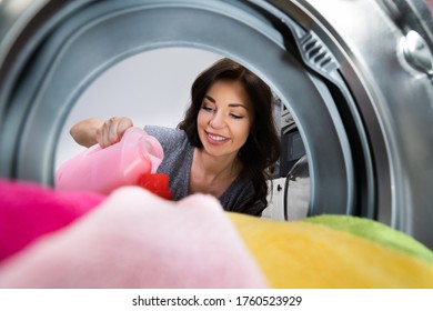 Woman Washing Clothes Using Washer Machine And Laundry Soap