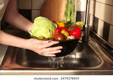 Woman washing different vegetables in metal colander, closeup - Powered by Shutterstock