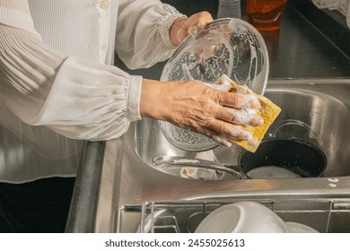 Woman washing dirty pan in sink in kitchen, closeup - Powered by Shutterstock