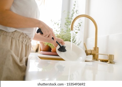 Woman washing dishes in the kitchen. Close up of woman hand. Housewife clean dishes