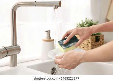 Woman washing dishes in kitchen sink, closeup. Cleaning chores - Powered by Shutterstock