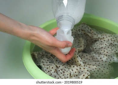 Woman Is Washing Dress From Delicate Fabric By Hands In Basin And Pouring Rinser. Laundry By Hands At Bathroom, Closeup View. Washing At Home, Housekeeping And Housework.