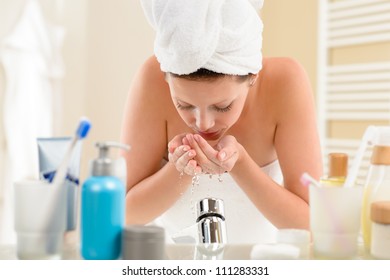 Woman Washing Face With Water Above Bathroom Sink