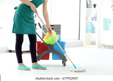 Woman washing floor in office. Cleaning service concept