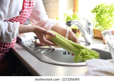 Woman washing fresh celery in kitchen sink, closeup - Powered by Shutterstock