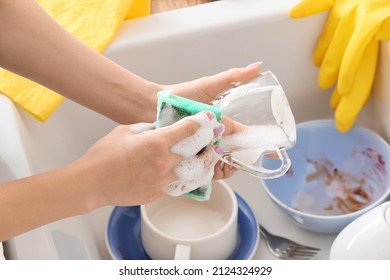 Woman Washing Glass Cup With Sponge Over Sink, Closeup