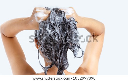 Woman washing hair with shampoo.