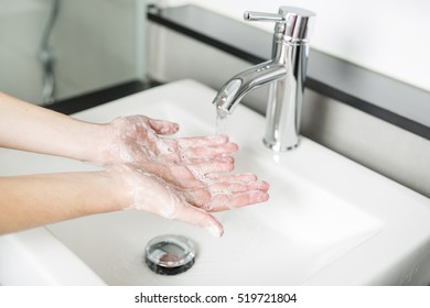 A woman washing hand on the sink - Shutterstock ID 519721804