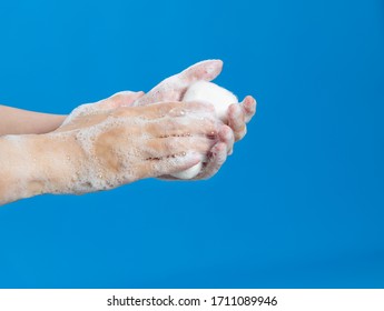 Woman Washing Hands With Soap On Blue Background.