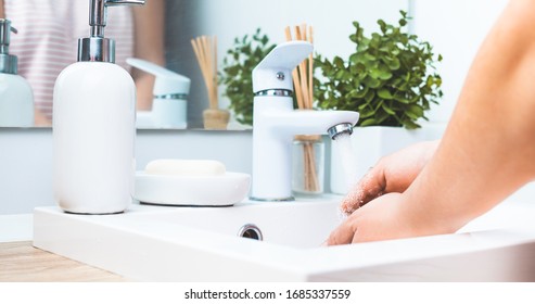 Woman Washing Hands In White Sink. Prevent Spread Of Virus, Wash Your Hands Regularly With Soap. Water Running From White Faucet. White Soap Dispenser With A Free Space For Your Text