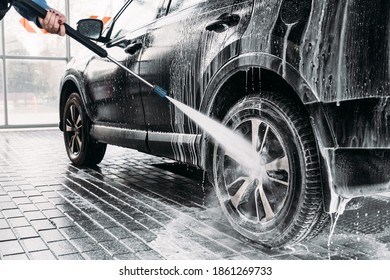 Woman washing her car in a self-service car wash station.Car wash self-service. 