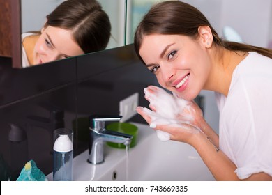 Woman Washing Up Her Face With Foam Cleanser In The Morning