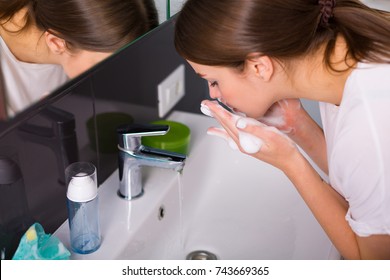 Woman Washing Up Her Face With Foam Cleanser In The Morning