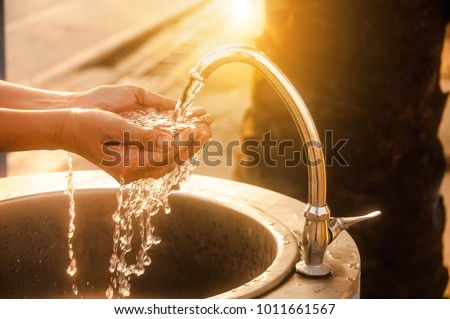 Woman washing her hands at the tap,Water shortage concept
