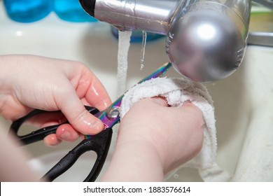 A Woman Washing Kitchen Shears In The Sink