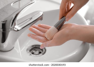 Woman Washing Makeup Brush Under Water