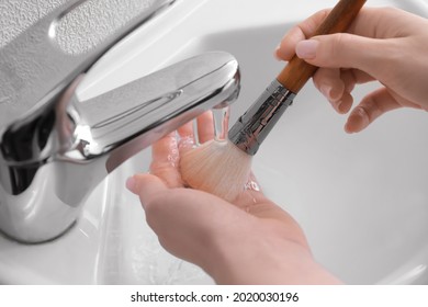 Woman Washing Makeup Brush Under Water